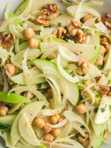 Fresh apple fennel slaw with chickpeas, walnuts, and herbs in a light dressing.