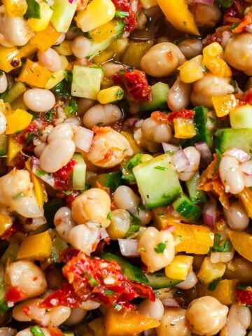 Dense Bean Salad with white beans, chickpeas, corn, yellow bell pepper, cucumber, and sun-dried tomatoes.