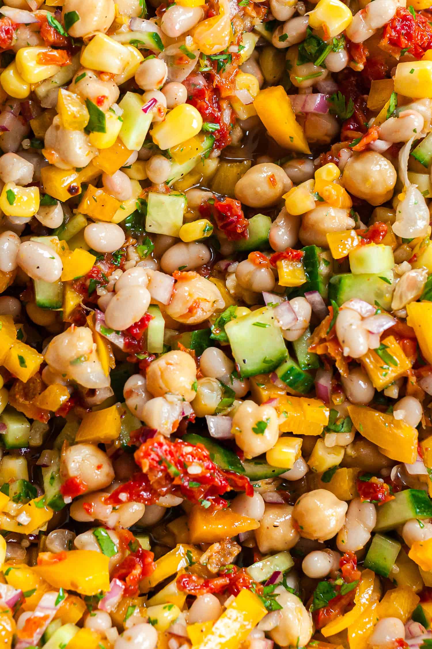 Healthy, hearty Dense Bean Salad recipe, showing all the colorful ingredients mixed together.
